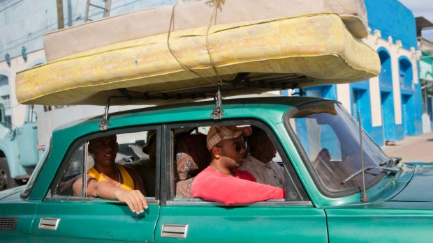 People carry their mattresses on a car toward a shelter prior the arrival of the Hurricane Matthew in Santiago, Cuba.