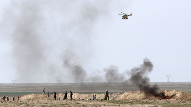 An Iraqi Army helicopter flies over security forces and Popular Mobilisation forces at the front line with Islamic State group militants in Anbar, Iraq, on Wednesday.