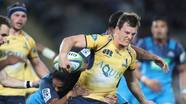 James Dargaville of the Brumbies is wrapped up by the Blues defence.