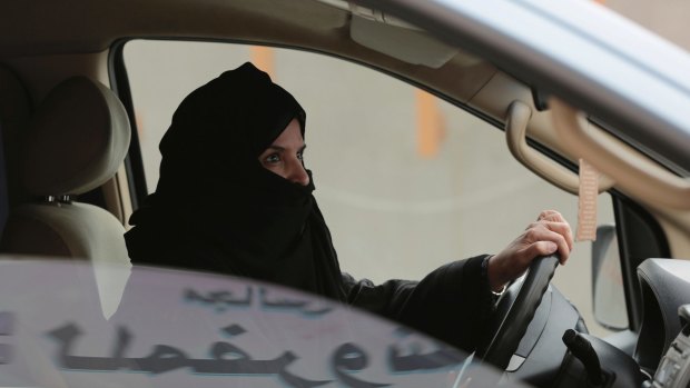 Aziza Yousef drives a car on a highway in Riyadh, Saudi Arabia, as part of a campaign to defy Saudi Arabia's ban on women driving in 2014. 