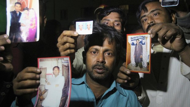 Pakistanis display missing family members following a bomb blast at a Sufi shrine.