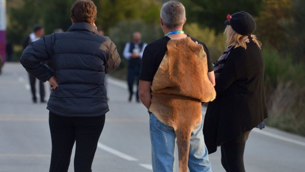 A man wears a kangaroo skin to the Anzac commemorative site for the dawn service,