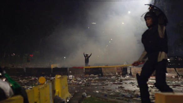 Police and a protester gesturing during the violent clashes in Jakarta. 