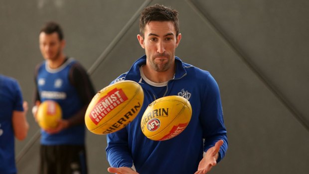 North Melbourne defender Michael Firrito keeps his eye firmly on the ball at training.