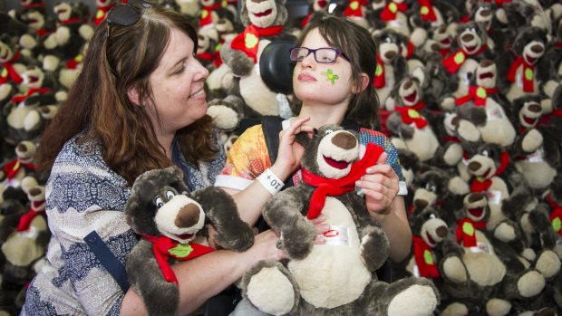 Melissa Keith and Lily (10) with some of the teddy bears being given out to children at the Canberra Special Children's Christmas Party at Thoroughbred Park on Sunday.
