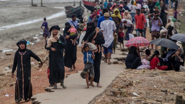 Rohingya Muslims, who crossed over from Myanmar into Bangladesh, walk towards the nearest refugee camp at Teknaf.