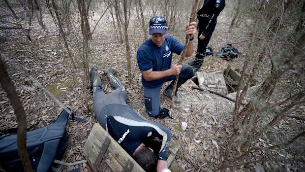 Police searching an underground water tank on Saturday. 