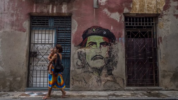 A woman carries a child along a street in Old Havana. Since the 1970s, the birthrate in Cuba has been in free fall.