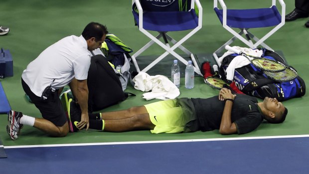 Down and out: Nick Kyrgios receives medical treatment on centre court.