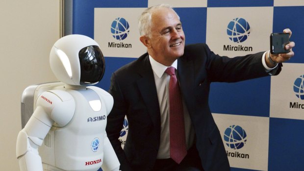 Malcolm Turnbull takes a selfie with Honda's robot Asimo.