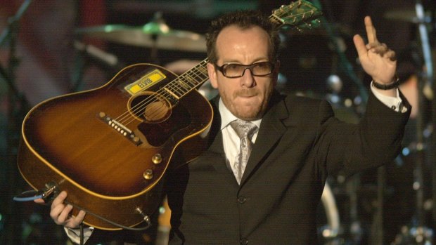 Elvis Costello waves to the audience after performing  during the Rock and Roll Hall of Fame induction ceremony in 2003, at New York's Waldorf Astoria. 