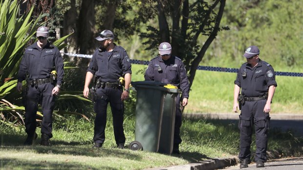 Police officers look for evidence close to a house after a 15-year-old boy was shot in the head at a home.
