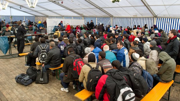 Refugees wait to be registered in tent at the train station in the Bavarian city of Passau, Germany on Monday.