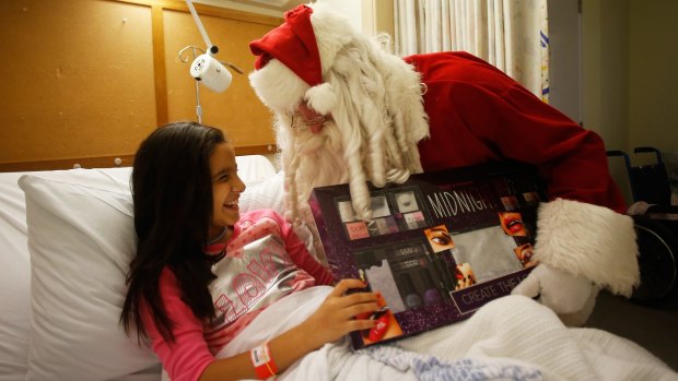 Zoe Labban receives a present from Santa on Christmas Day at Westmead Children's Hospital.