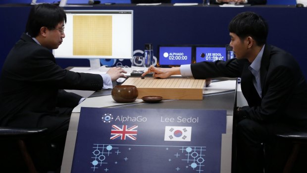 South Korean professional Go player Lee Se-dol, right, puts the first stone against Google's artificial intelligence program, AlphaGo, with Google DeepMind's lead programmer Aja Huang, left.