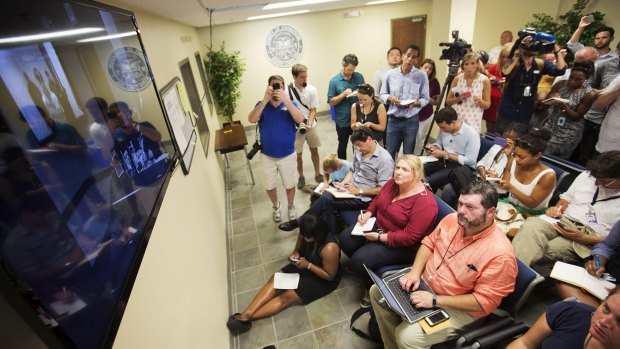 Dylann Roof appearing before a judge on Friday at his bond hearing as members of the media and public watch from a viewing room.