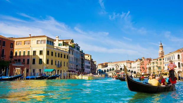Take a gondola ride through the Grand Canal to see Rialto Bridge.