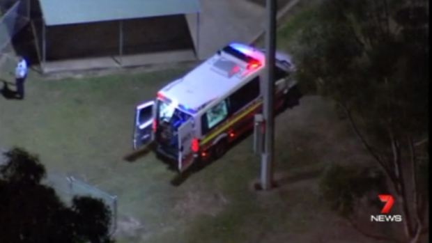An ambulance waits in Glenmore Park where a woman was stabbed multiple times.