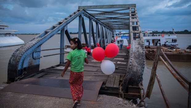 A girl holds balloons at the pier in Yangon ahead of Myanmar's landmark November 8 election.