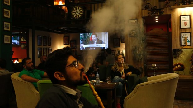 Lebanese patrons smoke water pipes at a coffee shop as they listen to Saad Hariri's live broadcast from Saudi Arabia on Sunday.