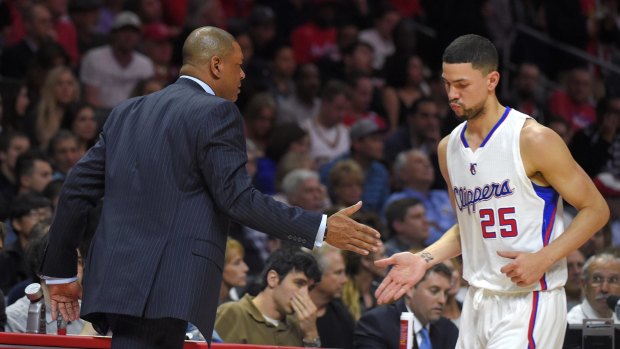 On you go, son: Los Angeles Clippers guard Austin Rivers slaps hands with his father, Clippers coach Doc Rivers, as he comes out of the NBA basketball game during the first half against the Cleveland Cavaliers on Friday in Los Angeles. 