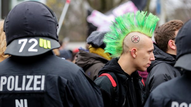  A protester with a crossed out swastika symbol painted on his head joins a march against the convention of the German anti-immigration 'Alternative for Germany' party ('Alternative fuer Deutschland', AfD) who over the weekend elected a a right-wing nationalist to be their co-leader.