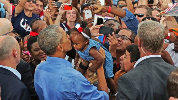 President Barack Obama kisses a young child during a campaign event in Kissimmee, Florida.