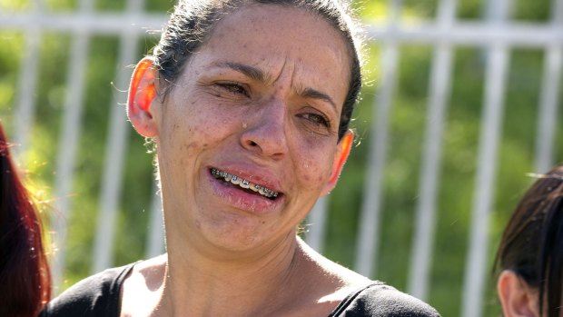 Angela Pereira de Souza, whose husband was shot dead in a bar, cries outside a police station in Osasco, Brazil, on Friday.