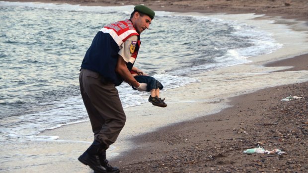 A police officer carries three-year-old Aylan Kurdi after he drowned near the Turkish resort of Bodrum.