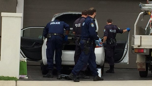 Police search a car during a raid on a house in Lockwood Street, Merrylands, in Sydney's west on Wednesday.