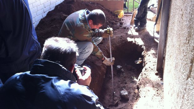 Police examine the site where Ketani was buried in suburban Johannesburg.