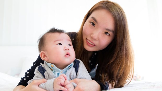 Jenny Huh with her six-month-old son, Chris Jung. Ms Huh had a facial tumour removed when she was pregnant.