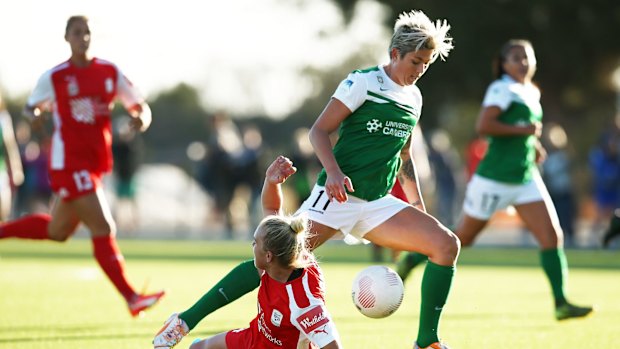 Canberra United striker Michelle Heyman runs with the ball over Adelaide's Grace Abbey.