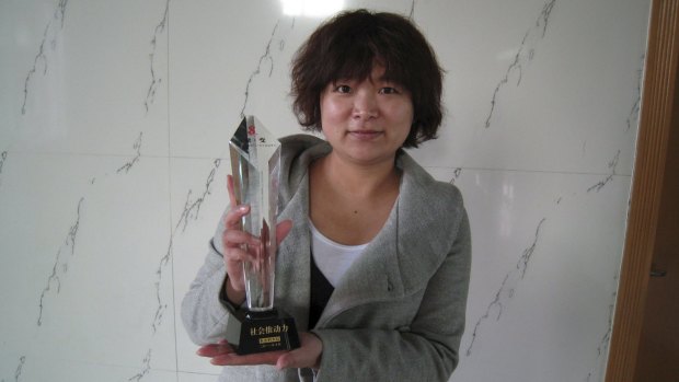 Female activist Wu Rongrong, 30, with a trophy.