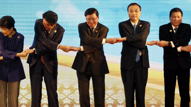From left: South Korean President Park Geun-hye, Japan's Prime Minister Shinzo Abe, Laos' Prime Minister Thongloun Sisoulith, Chinese Prime Minister Li Keqiang and Philippine President Rodrigo Duterte link arms during the ASEAN summit  earlier this month.