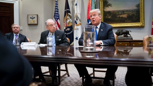 From left, Republican senators Lindsey Graham and Chuck Grassley  listen as US President Donald Trump speaks at the White House, January 2018.  