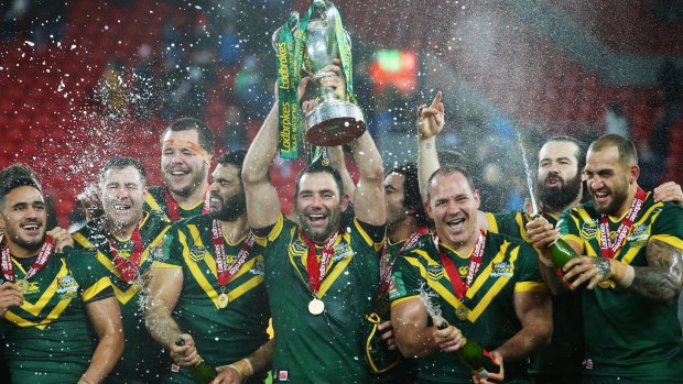 On top of the world again: Cameron Smith lifts the trophy with teammates after victory in the Four Nations final.