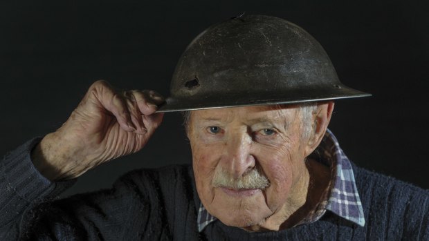 Joe Mullins, who turns 95 in July, with his helmet which was pierced by bullets during combat in 1945.