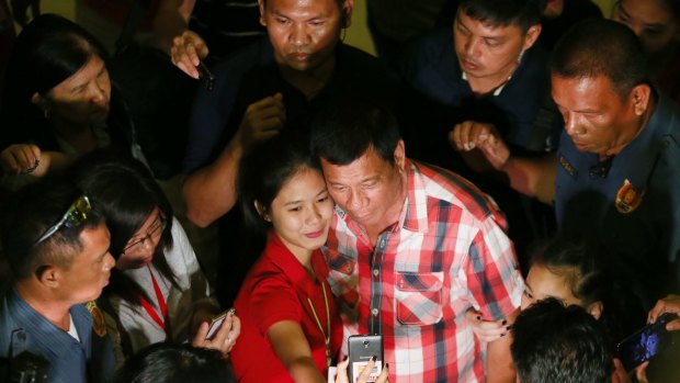 Even before the polls closed Mr Duterte, here in a selfie with a supporter, called for an end to acrimony.