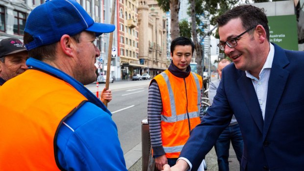 Premier Daniel Andrews greets construction workers in Federation Square.
