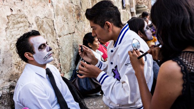 Mexicans have scary make-up applied to take take part in the Day of the Dead festival in Oaxaca.