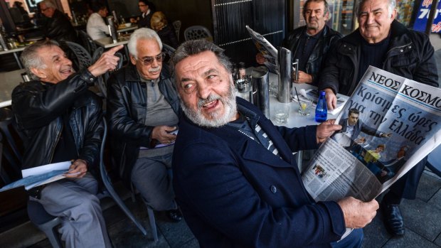 Read all about it: Peter Kanellakis discusses the headlines with friends in a cafe in Oakleigh.