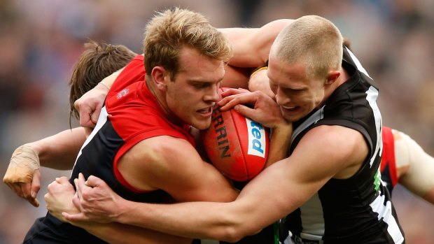 Jack Watts of the Demons is tackled by Jack Frost of the Magpies during the 2015 AFL round 18 match between the Collingwood Magpies and the Melbourne Demons at the Melbourne Cricket Ground.