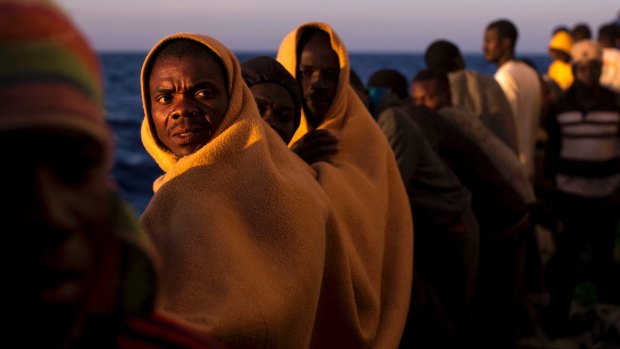 Men rescued from boats coming from Libya stand on the deck of a rescue vessel in the Mediterranean in June. 