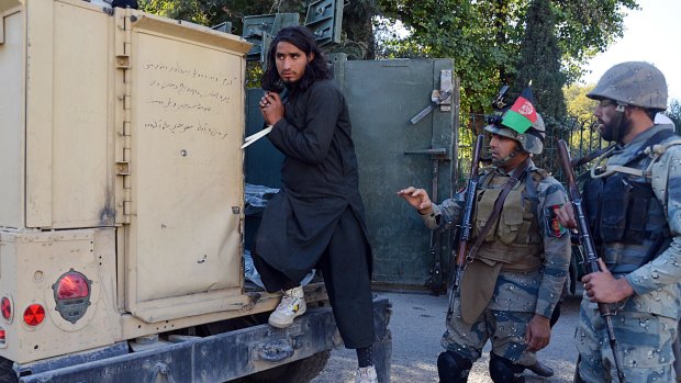 A Taliban fighter gets out of a police vehicle in Jalalabad on Tuesday. 