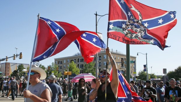 A group carries Confederate flags, one bearing the legend "Don't Tread On Me", past a Black Lives Matter rally in Oklahoma City.