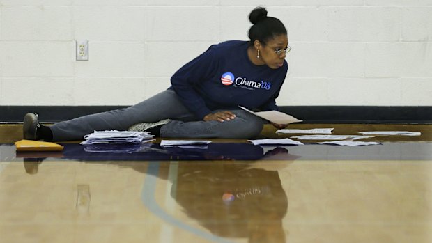 Caucus volunteer Akilah Stewart sorts  registration forms by precinct at Garfield High School in Seattle. 