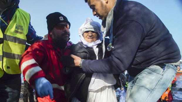 Volunteers help an elderly woman from Afghanistan from a dinghy in the village of Skala Sykaminias, on the north-eastern Greek island of Lesbos on January 27, 2016. 