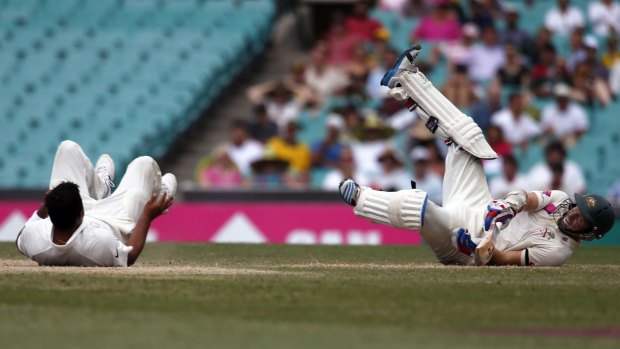 The fall guys: Chris Rogers, right, lies on the ground after colliding with India’s Suresh Raina on Friday.