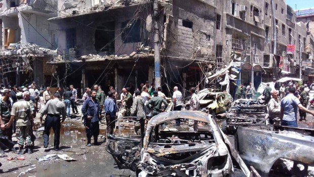 Syrians gather around damaged buildings after am attack in Sayyida Zeinab, Damascus.